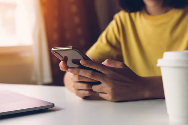 mulher que prende o smartphone, usando o telefone de pilha no café. tecnologia para o conceito de uma comunicação. - for - fotografias e filmes do acervo