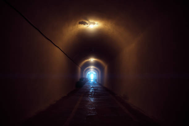 istock Underground dark tunnel with lamp illumination and blue light in end 1145730573