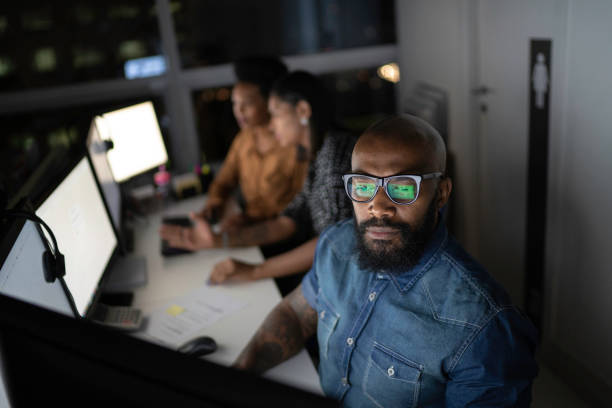 Businessman working late in the office Businessman working late in the office group of people men mature adult serious stock pictures, royalty-free photos & images