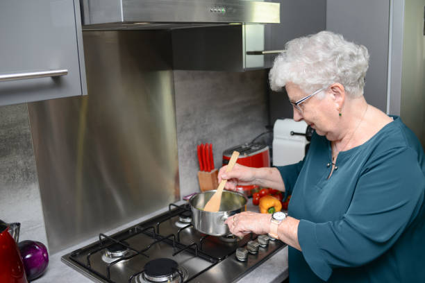 istock happy senior active woman cooking at home in a modern kitchen 1145742403