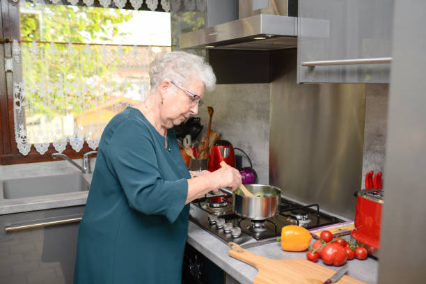 istock happy senior active woman cooking at home in a modern kitchen 1145742411