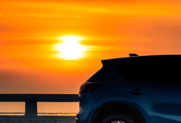 스포츠와 현대적인 디자인 블루 컴팩트 suv 자동차 저녁 일몰에 바다에 의해 콘크리트도로에 주차. 하이브리드 및 전기 자동차 기술 개념입니다. 주차 공간. 자동차 산업. - car stationary blue sky 뉴스 사진 이미지