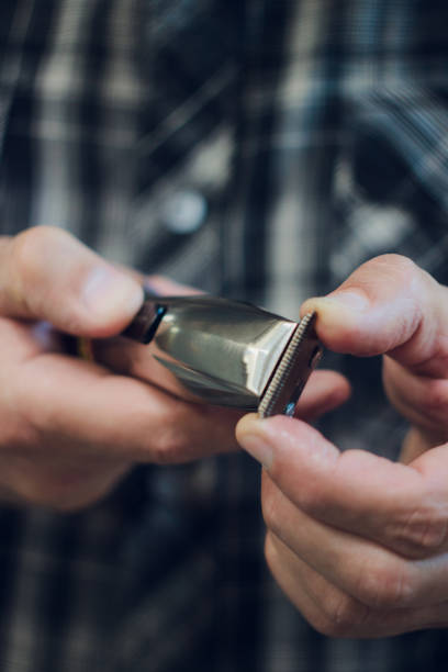 istock Electric hair trimmer. Barber's hands with holding razor 1145747061