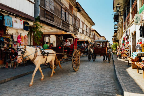 The local scene with traditional horse carriages in Calle Crisologo of Vigan City in the province of Ilocos, Philippines. stock photo