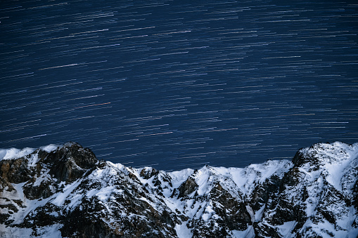 Star filled sky over remote snow capped mountains in Japan