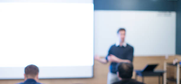 istock Speaker at Talk in Business Conference. Tech Executive Entrepreneur Speaker on Stage at Conference. Presenter Giving Business Presentation at Meeting. Corporate Exhibition for Investors Event. 1145763306