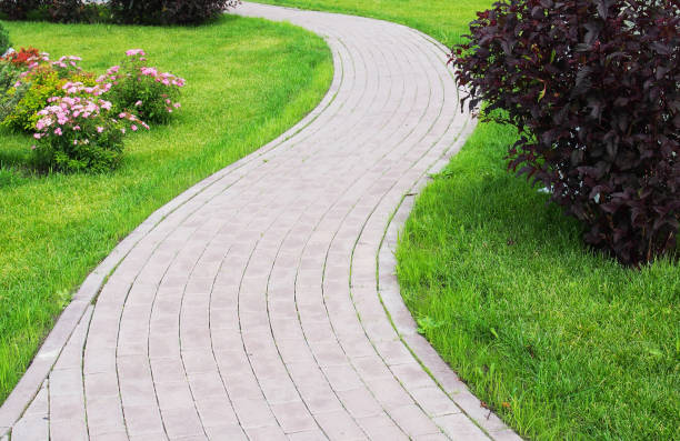 istock Curved paved with bricks footpath running ahead along a green grassy lawn. Landscaping design 1145764188