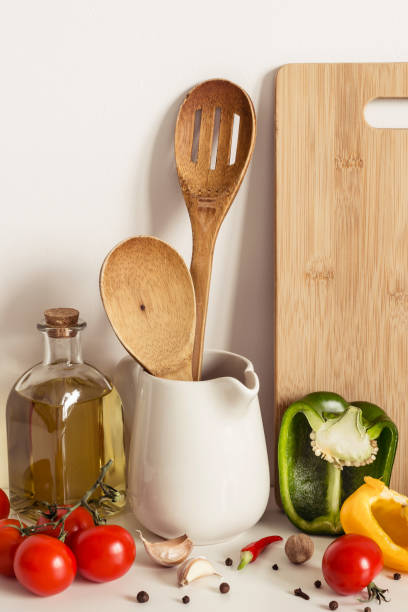 istock Wooden Kitchenware, vegetables and olive oil on table wall background 1145764236