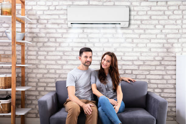istock Couple Sitting On Couch Under Air Conditioner 1145767020