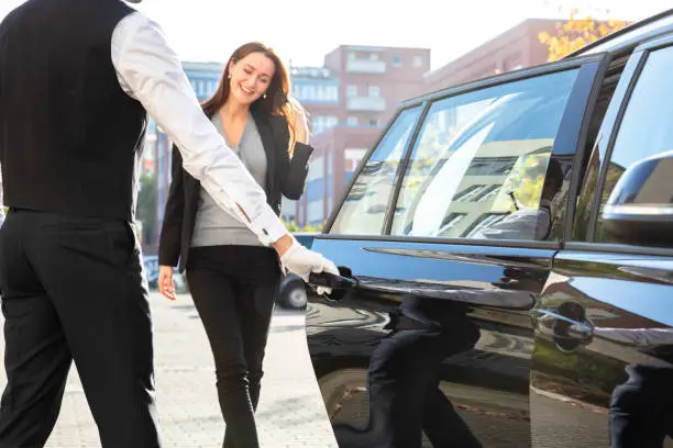 Photo of Chauffeur Opening Door For Businesswoman