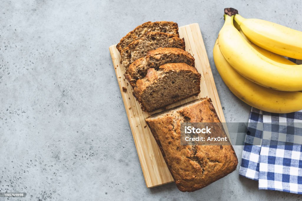 Banana bread loaf on concrete background top view Banana bread loaf with almond nuts sliced on grey concrete background. Table top view and copy space Banana Bread Stock Photo