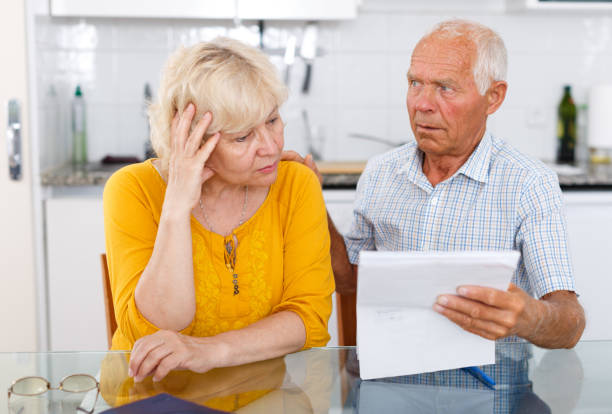 istock Upset mature family couple with documents at kitchen table 1145770044