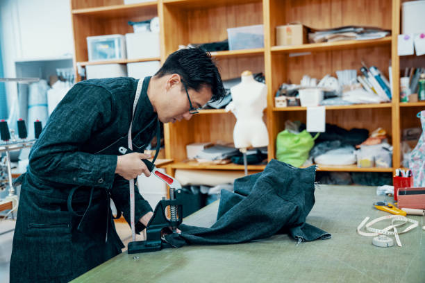 istock Mid adult tailor making a denim jacket in his textile studio 1145772366