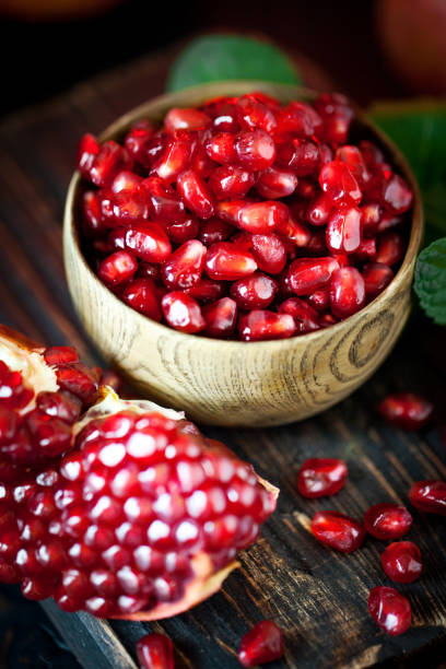 istock Ripe pomegranate fruit on a old black wooden vintage background. Selective focus. 1145773907