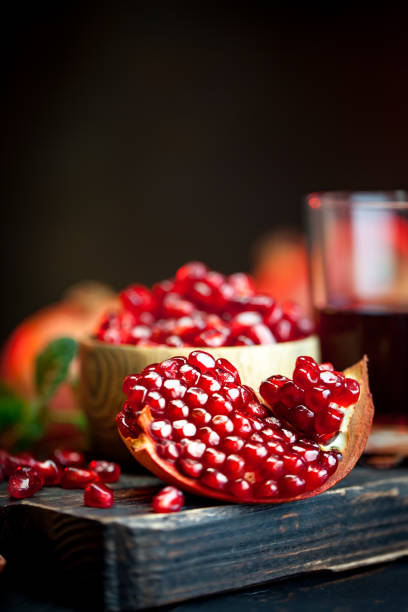 istock Ripe pomegranate fruit on a old black wooden vintage background. Selective focus. 1145774156