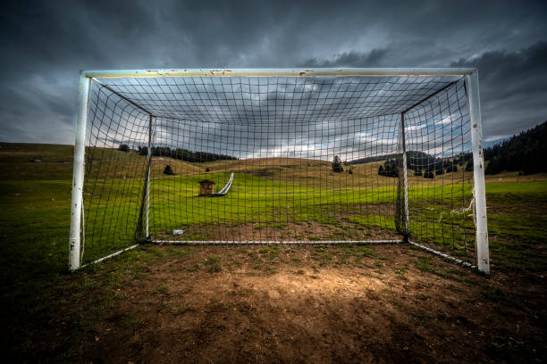 Green football field under blue sky background