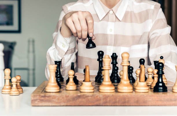 istock Wooden chess pieces on a chessboard, chess game woman player makes a move 1145776018