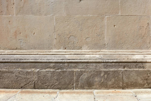 istock Ancient stone wall with molding and floor background in sunlight, empty space 1145776598