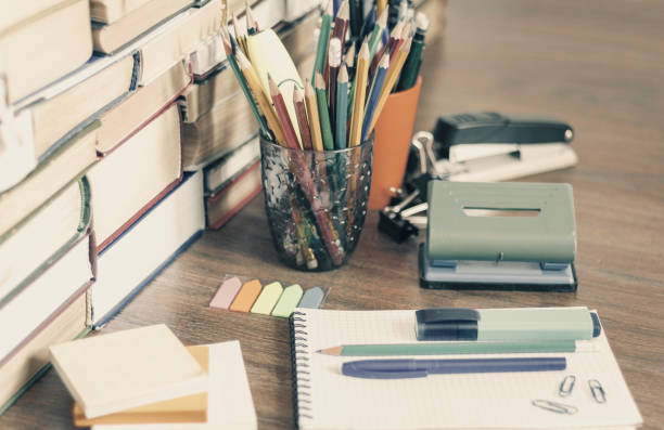 istock School stationery accessories - notebook, copybook stack with plastic holder pencils, pens, markers, paper clips, stickers, notepads, sharpener with stack of books education concept background 1145776620
