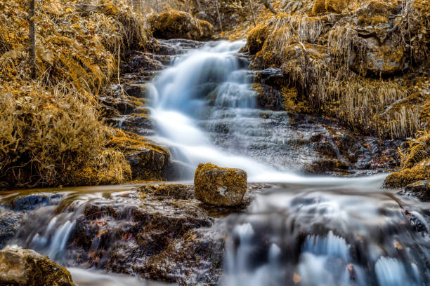 scena z górskim wodospadem i skałą na pierwszym planie jesienią - natural phenomenon waterfall rock tranquil scene zdjęcia i obrazy z banku zdjęć