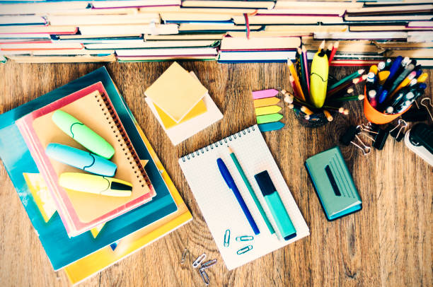 istock School stationery accessories - notebook, copybook stack with plastic holder pencils, pens, markers, paper clips, stickers, notepads, sharpener with stack of books education concept background 1145776645