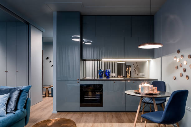 Dark interior with open kitchen Dark home interior in blue with open kitchen and dining area with round table small stock pictures, royalty-free photos & images
