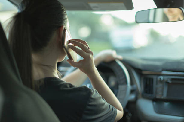 mujer distraída hablando en su teléfono mientras conducía. - driving car distracted accident fotografías e imágenes de stock