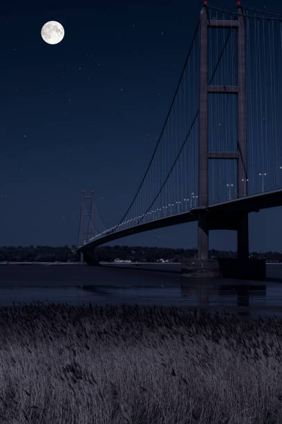 istock Digital composite image of the Humber Bridge processed to represent a night time view with a full moon and stars overhead. 1145781194