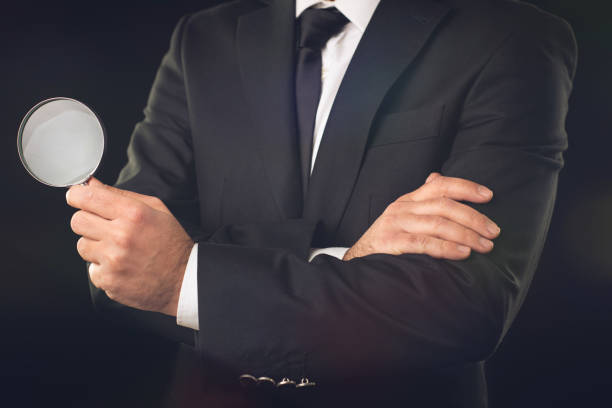istock Businessman with Magnifying Glass on Dark Background 1145783078