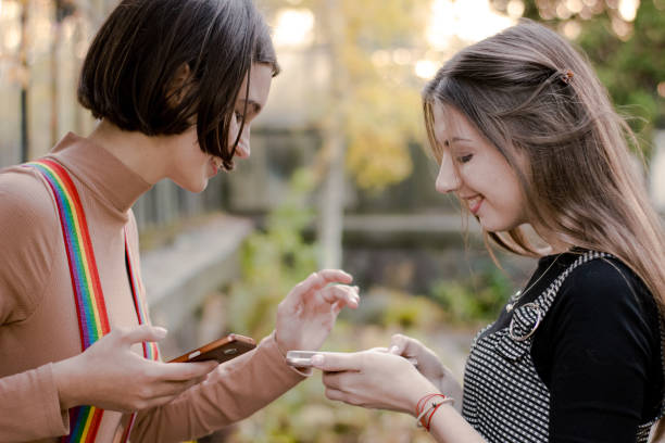 istock Two smiling students looking at the phone in the autumn park 1145784341