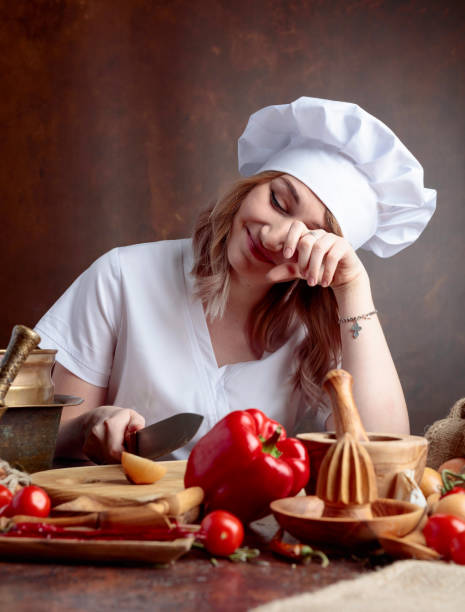 istock Young woman in a chef uniform cuts onions and cries. 1145788200