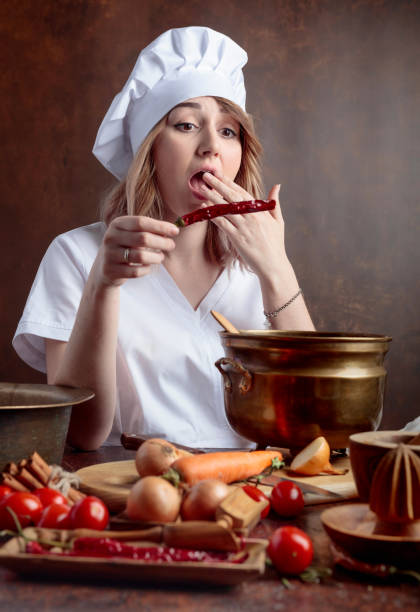 istock Young womanin a chef uniform with red pepper. 1145788207