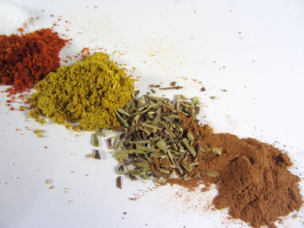 Various spices Various ground spices, including black pepper, paprika, salt, nutmeg, cinnamon, curry and origano, arranged in a row on white. majoran stock pictures, royalty-free photos & images