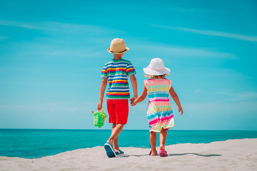 little boy and girl walking on beach vacation