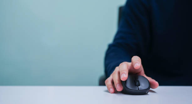 close up employee man hand using mouse cursor for scrolling web page or working on computer program at desktop in office concept - rato de computador imagens e fotografias de stock