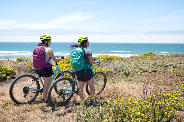 istock Multi-Ethnic Sisters with Bicycles Stop to Enjoy California Ocean View 1145806319