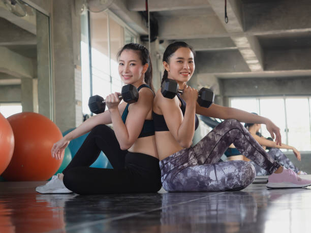 istock two woman is exercising with a dumbbell in gym 1145807382
