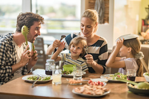 istock Playful family having fun during lunch time at dining table. 1145812478