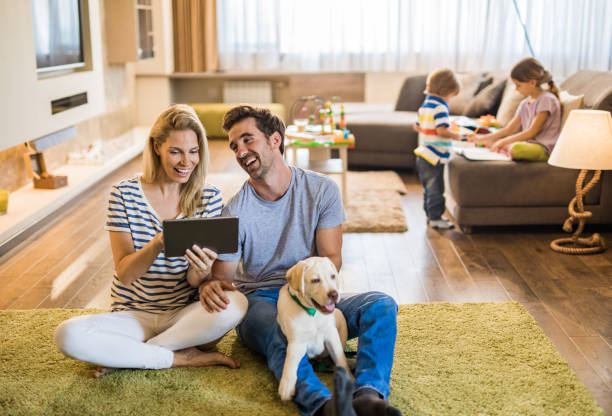 istock Young couple with their puppy having fun while using touchpad at home. 1145812815