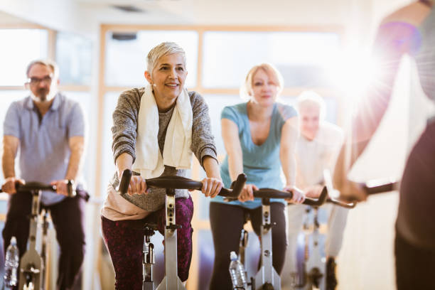 istock Group of athletic mature people having exercising class with an instructor in a gym. 1145814197
