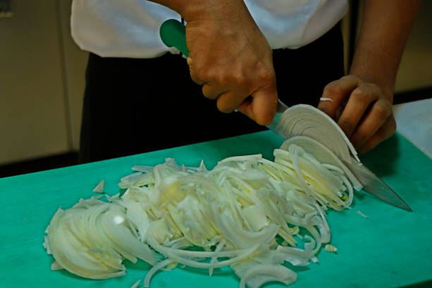 istock a chef slicing white onion on a green cutting board 1145814342