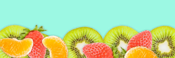 istock Kiwi slices, tangerines, strawberries on blue panoramic background. Fruits web banner. 1145814876