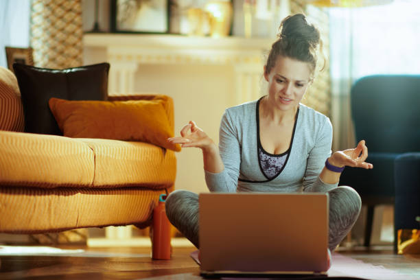 istock sports woman watching yoga tutorial on internet via laptop 1145815795