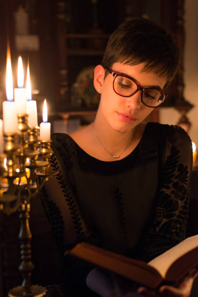 istock Woman reading the book under the candlelight 1145817149