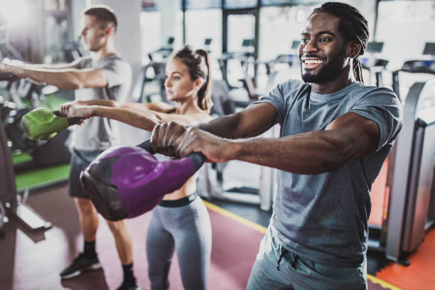 체육관에서 크로스 훈련에 주전자 종소리와 운동 선수의 그룹. - men weight training african descent male 뉴스 사진 이미지