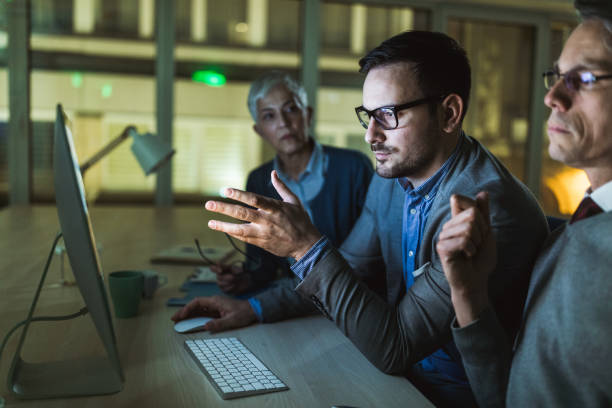 istock Business team cooperating while working on desktop PC late in the office. 1145817319