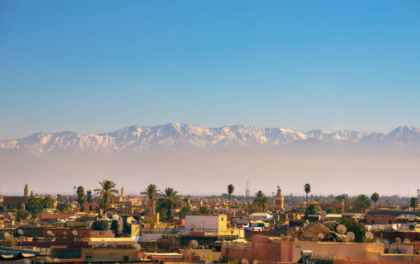 lo skyline della città di marrakech con le montagne dell'atlante sullo sfondo - atlas foto e immagini stock