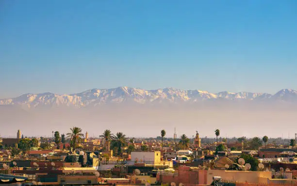 Marrakesh city skyline in Morocco with snowy Atlas mountains in the background