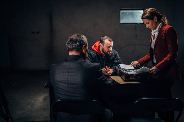 istock Two detectives investigating a man in investigation room 1145821366
