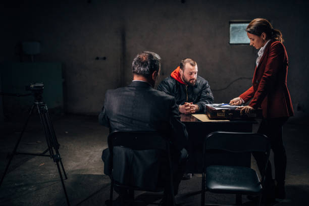 istock Two detectives investigating a prisoner in investigation room 1145821378